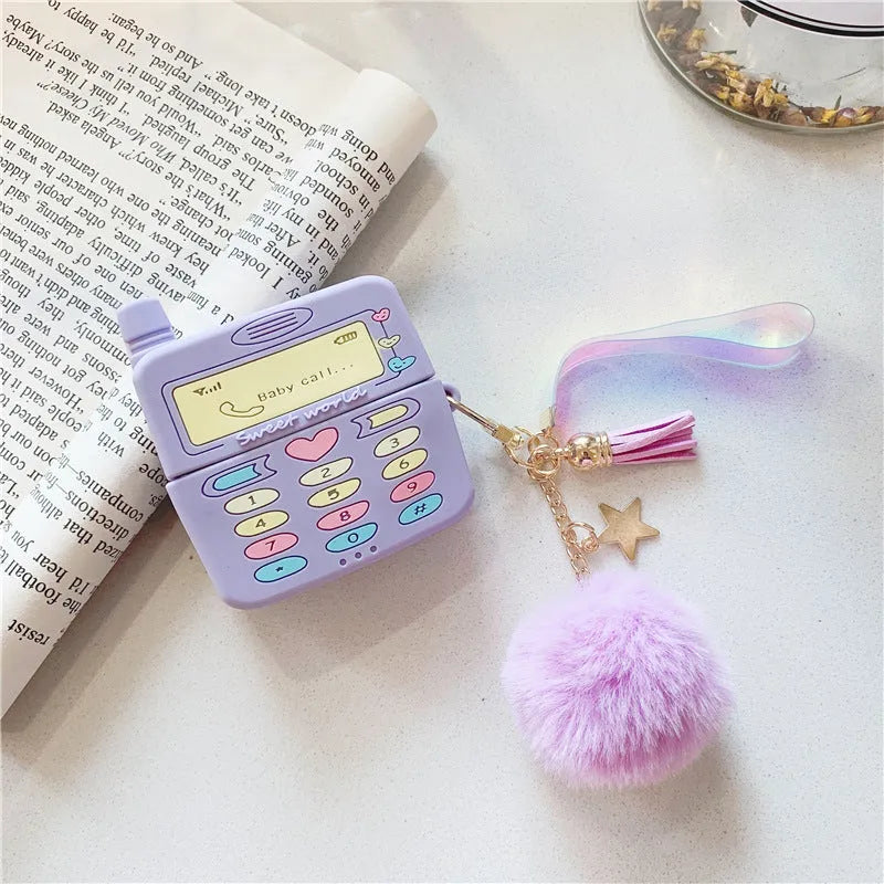Purple silicone AirPods protective case with fur ball pendant attached to clamshell design