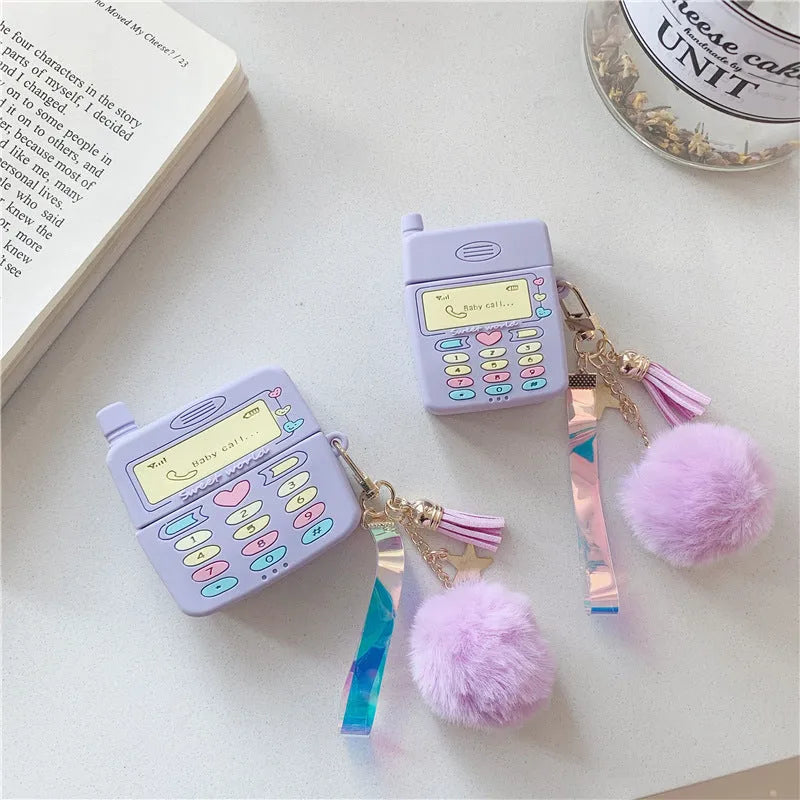 Purple silicone AirPods protective case with fur ball pendant attached to clamshell design
