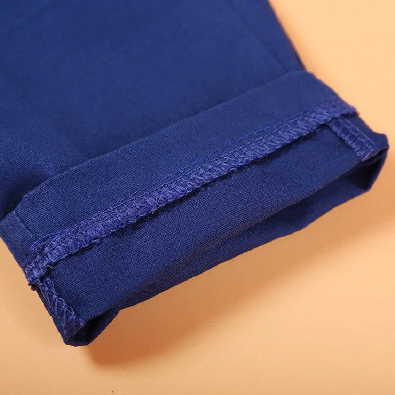 Blue three-piece boys suit with vest, tie, and trousers on a hanger