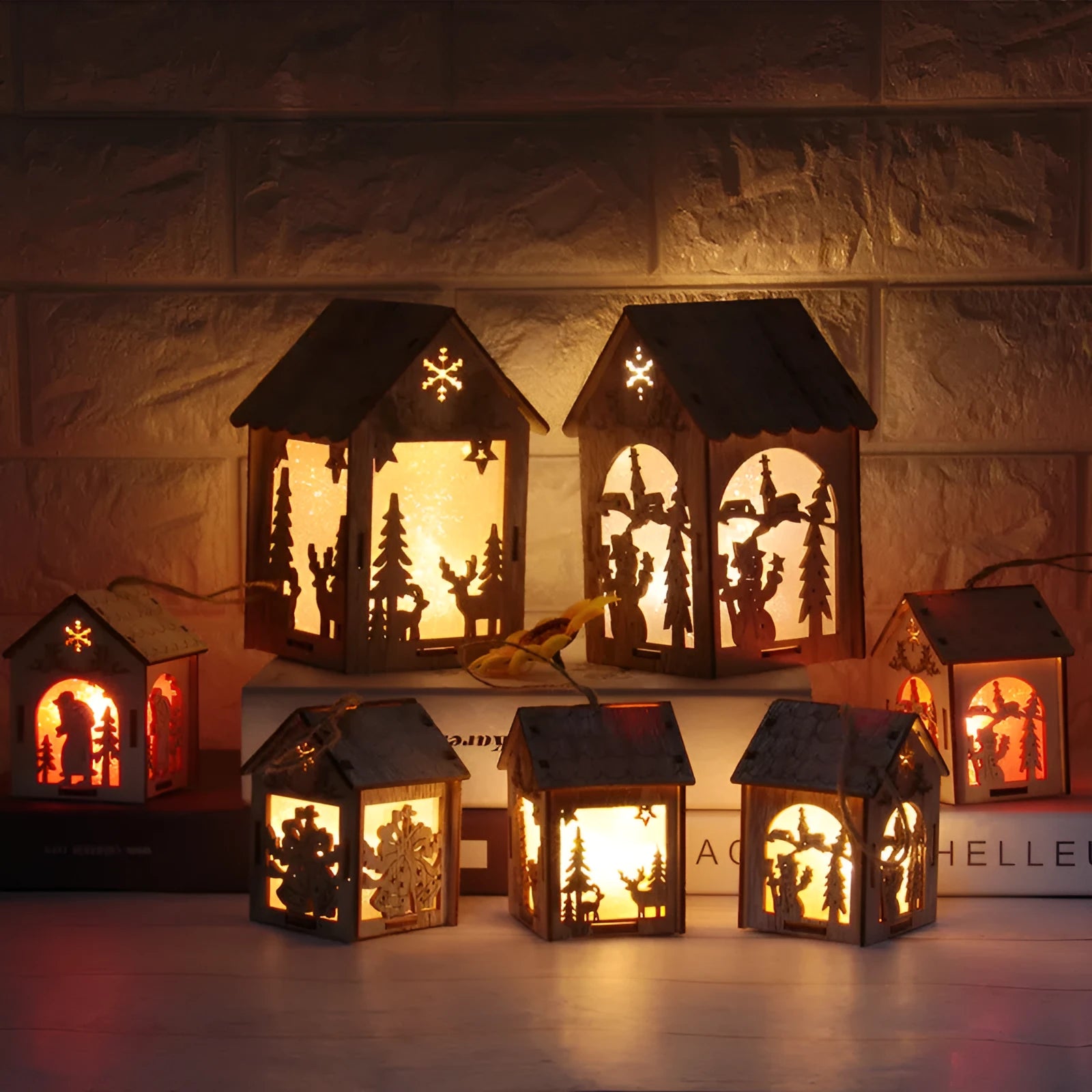 Set of three handmade wooden Christmas cottage ornaments: log bell, Santa house, and snowman house.