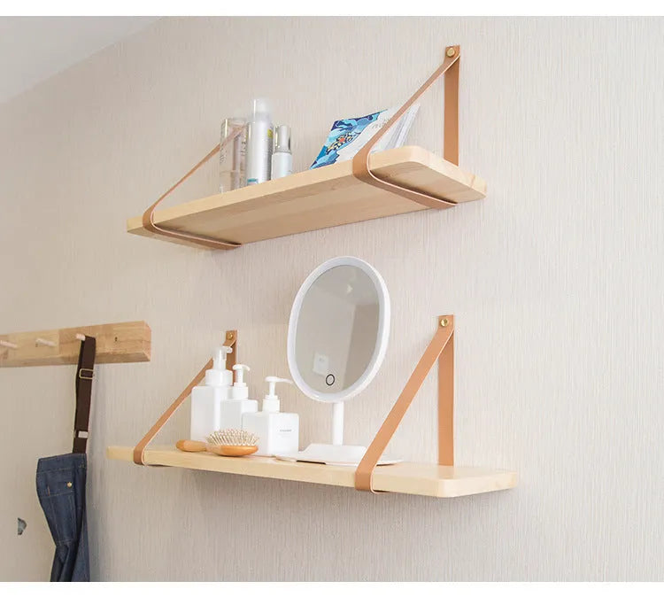 A narrow pine wood wall-mounted shelf unit for storing remote controls, books, and small items.