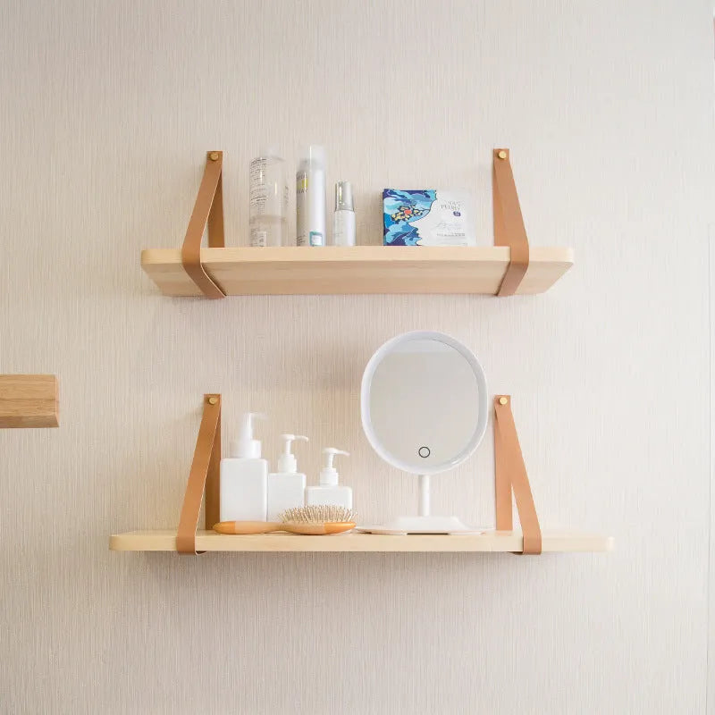 A narrow pine wood wall-mounted shelf unit for storing remote controls, books, and small items.
