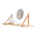 A narrow pine wood wall-mounted shelf unit for storing remote controls, books, and small items.