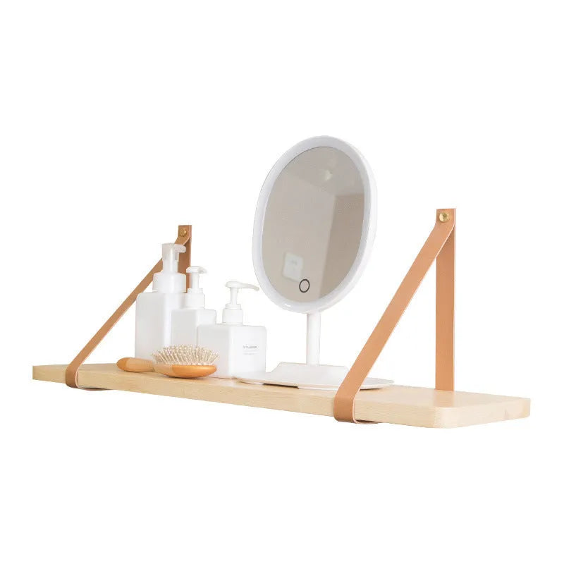 A narrow pine wood wall-mounted shelf unit for storing remote controls, books, and small items.