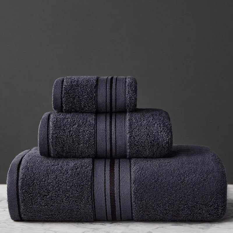 Three-piece cotton towel set showing bath towel, hand towel, and square scarf in solid blue colour