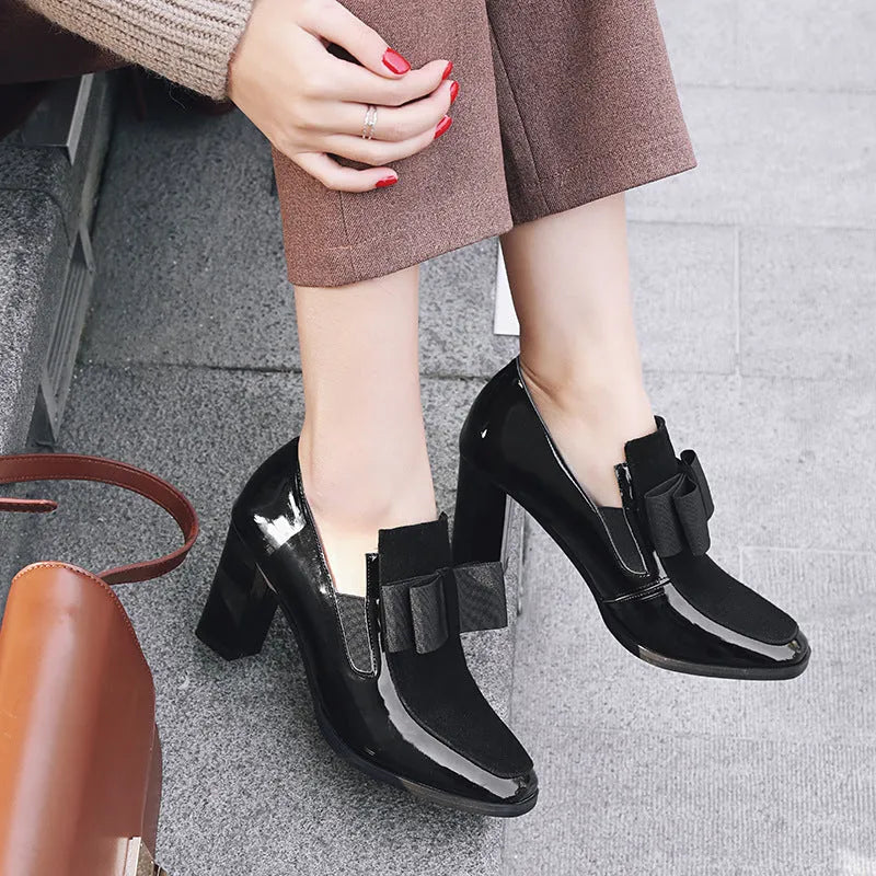Women's black patent leather high heels with a thick block heel and square toe.
