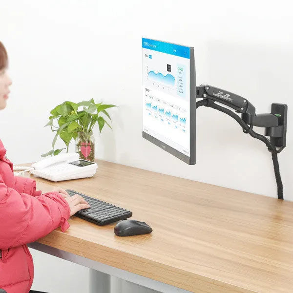 Black wall-mounted monitor stand with telescopic and rotating arm on a wall