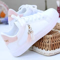 Women's white mesh casual shoes with pink accents and rubber sole on grey background