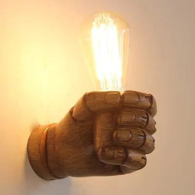 Creative resin fist-shaped wall lamp in black finish mounted on a wall.