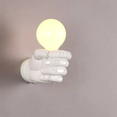 Creative resin fist-shaped wall lamp in black finish mounted on a wall.