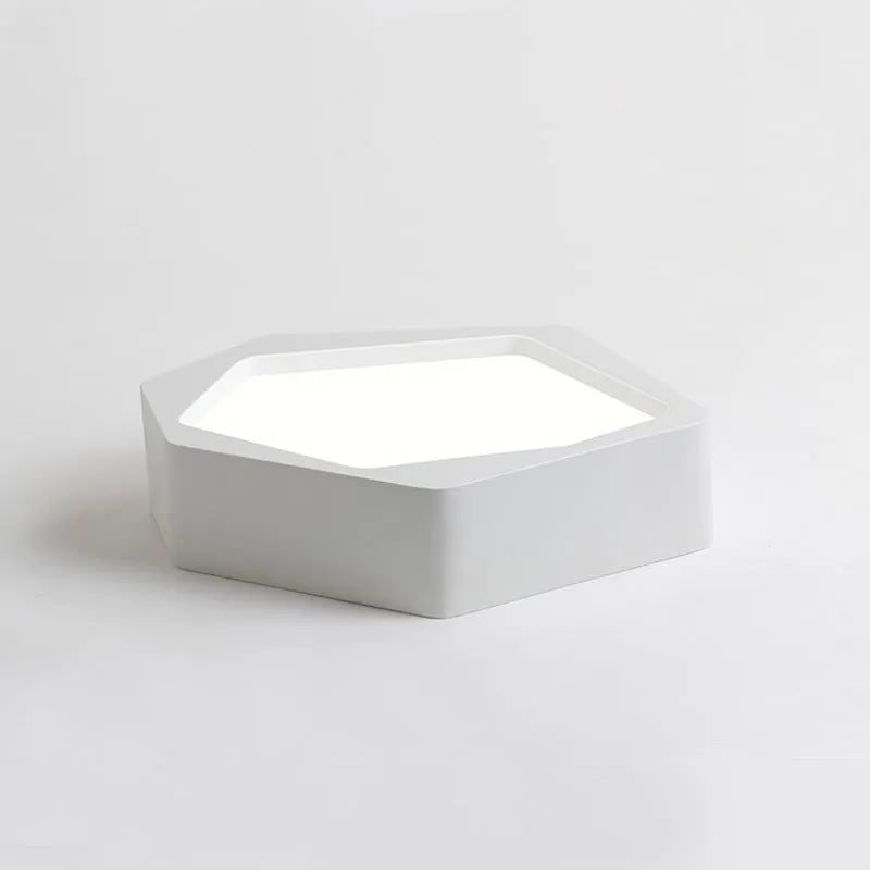 Geometric shaped iron LED light with black frame and remote control on a table.