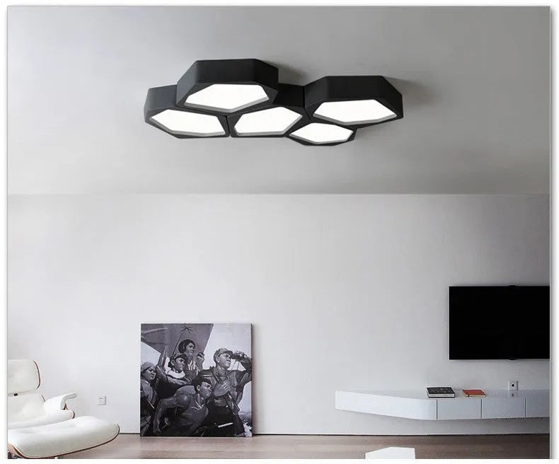 Geometric shaped iron LED light with black frame and remote control on a table.
