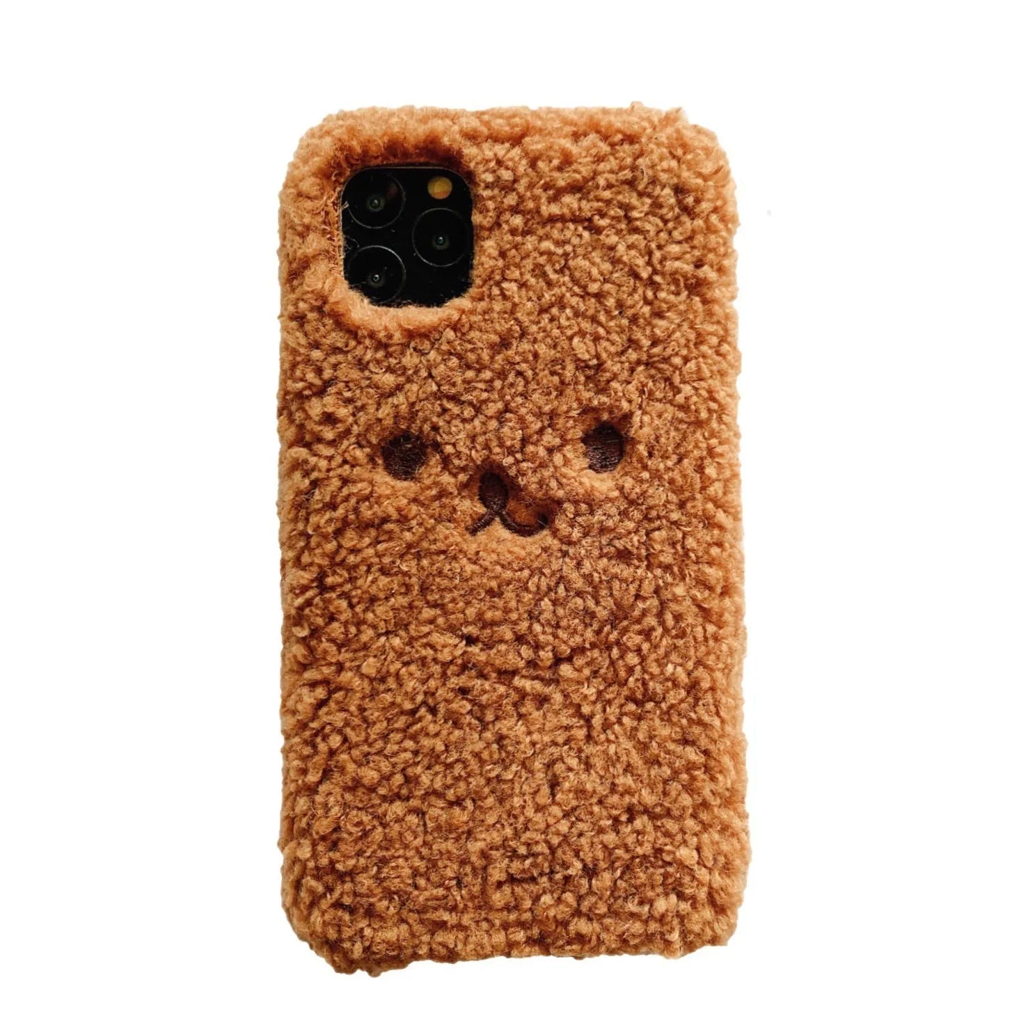 Brown embroidered plush bear face on a flexible TPU phone case for iPhone, showing camera cutout and raised edges.