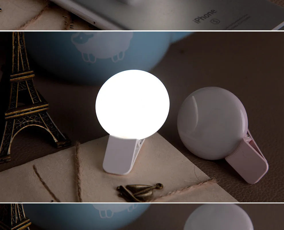 Round USB rechargeable LED fill light attached to a mobile phone for selfies.