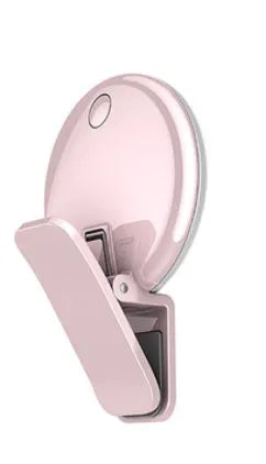 Round USB rechargeable LED fill light attached to a mobile phone for selfies.