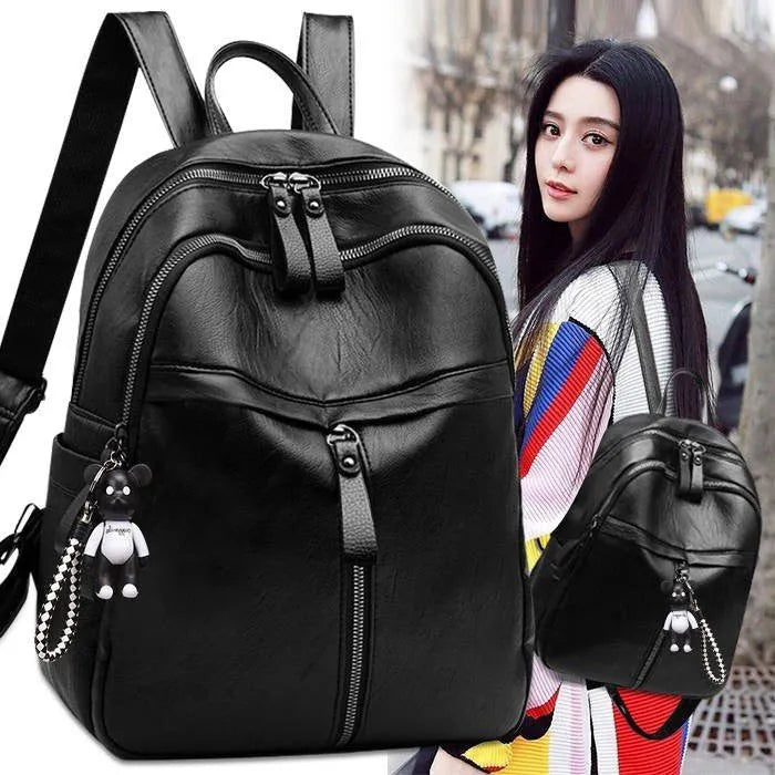 Black soft-surface pu leather backpack with double straps and luggage strap, showing main compartment.