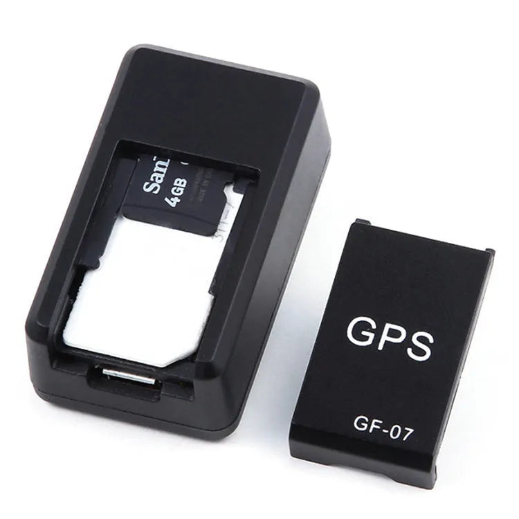 Small black magnetic GPS tracker device next to a USB charging cable on a table.