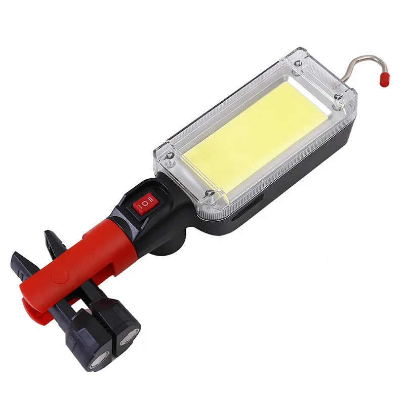 Red portable COB rechargeable work lamp with magnetic hook on a metal surface.