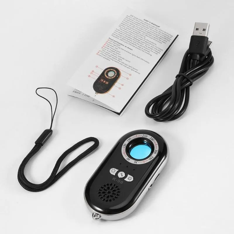 Compact black wireless signal detector with vibration alarm for security, shown next to a ruler for scale.