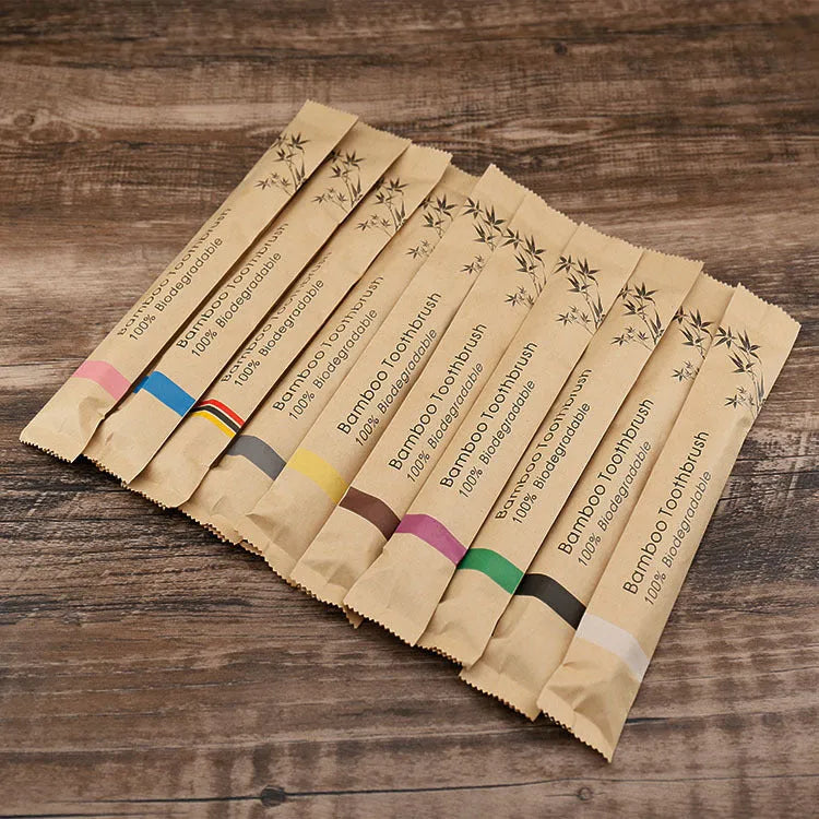 Set of ten bamboo toothbrushes with charcoal bristles in assorted colours on a plain background
