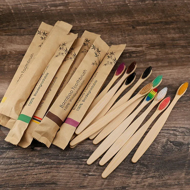 Set of ten bamboo toothbrushes with charcoal bristles in assorted colours on a plain background