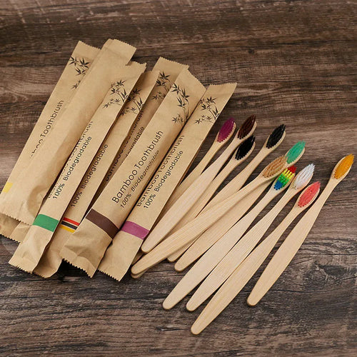 Set of ten bamboo toothbrushes with charcoal bristles in assorted colours on a plain background