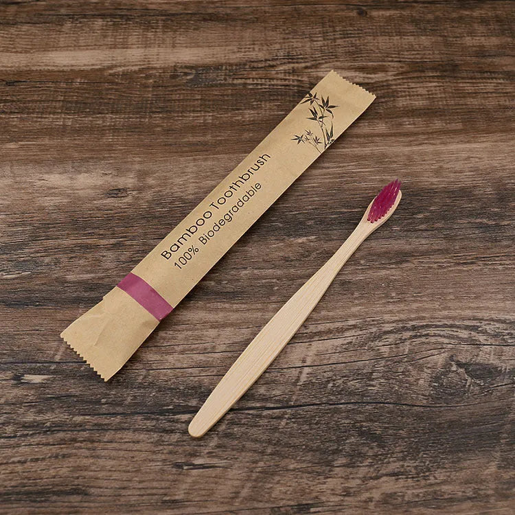 Set of ten bamboo toothbrushes with charcoal bristles in assorted colours on a plain background