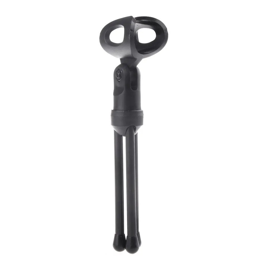 Black wired mini microphone with a metal clip-on gooseneck holder on a desk next to a laptop.