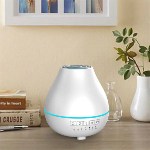 White round Bluetooth aroma diffuser with night light on wooden table, showing mist outlet and water tank.