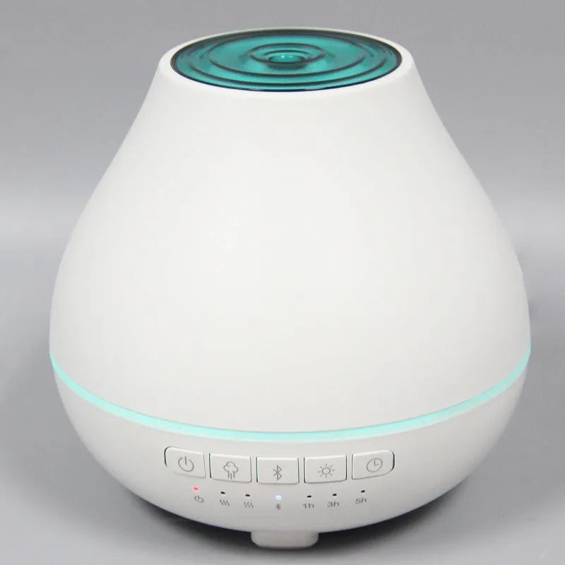 White round Bluetooth aroma diffuser with night light on wooden table, showing mist outlet and water tank.