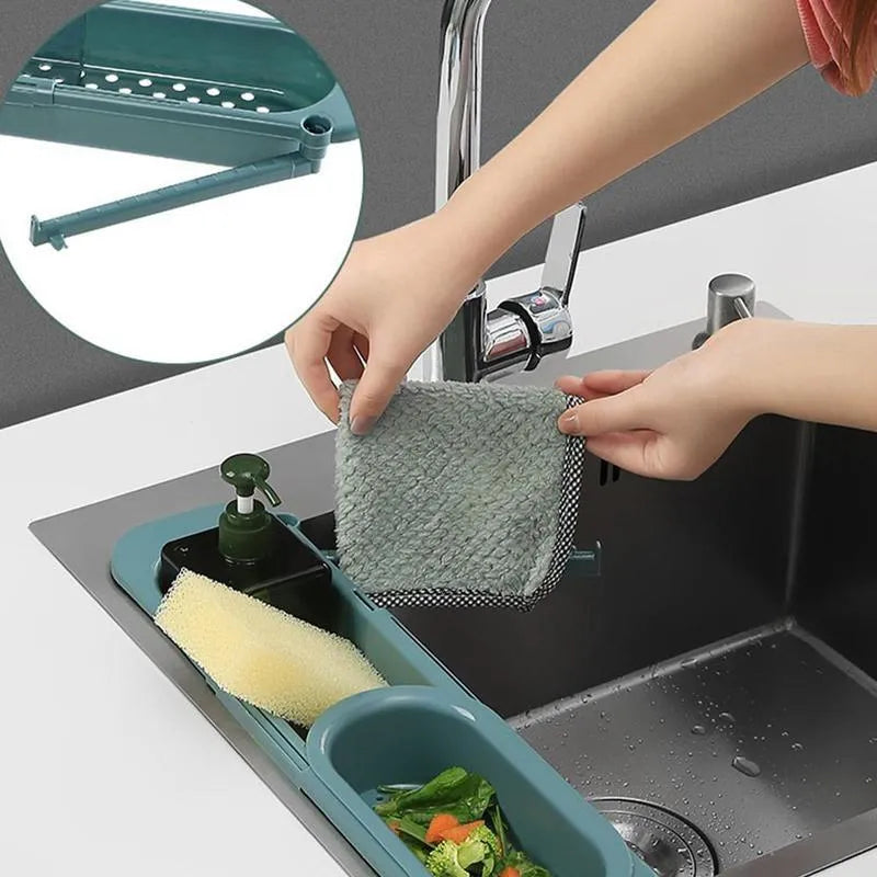 Blue grey adjustable telescopic sink rack organiser with drainer basket holding a sponge and soap bottle.