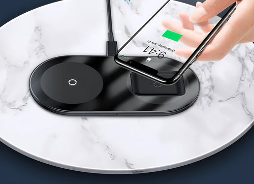 Baseus black wireless charging stand with iPhone on angled top and AirPods case on lower pad, showing foldable hinge.