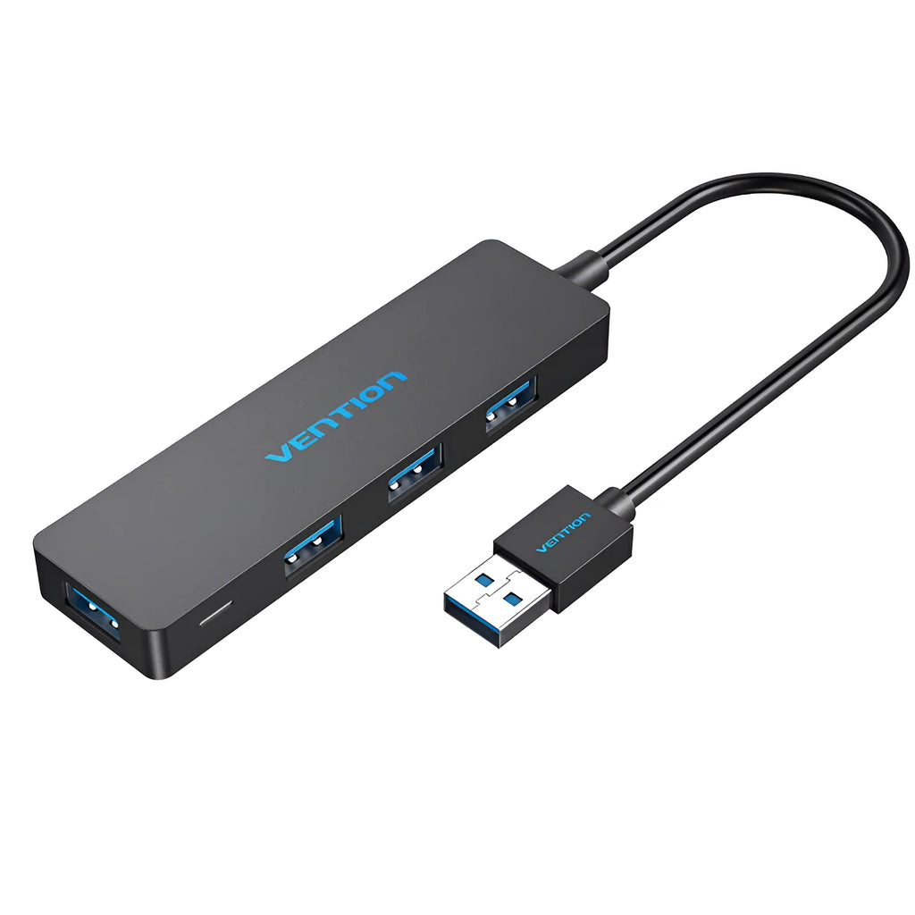 Black Wei Xun four-port USB 3.0 hub with short 15cm cable on a desk next to a laptop.