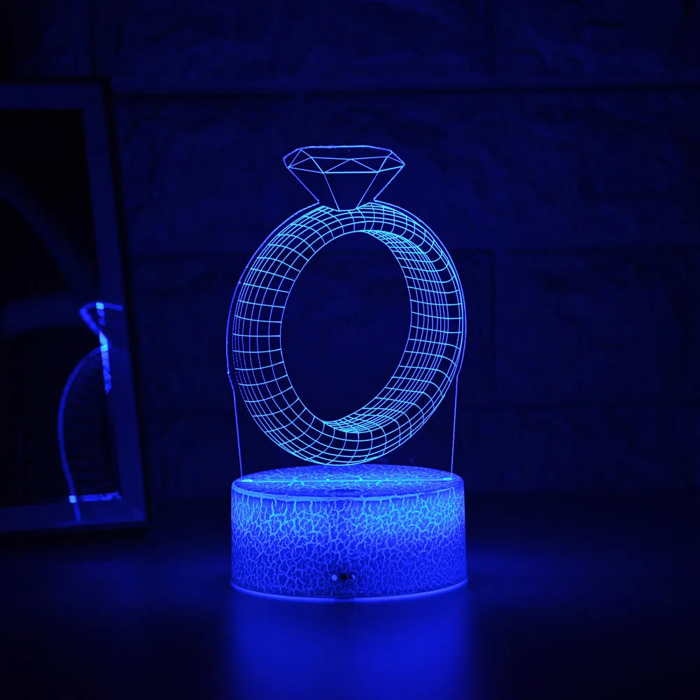 3D LED night light showing a holographic diamond ring design with colour-changing glow on a black base.