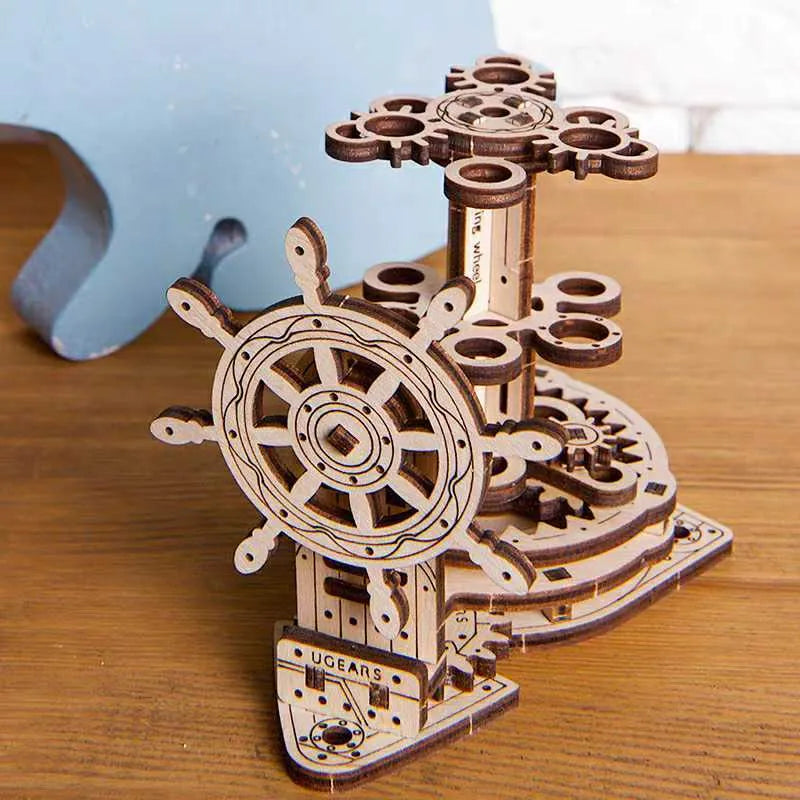 Assembled wooden steering wheel pen holder rotating on a desk with pens.