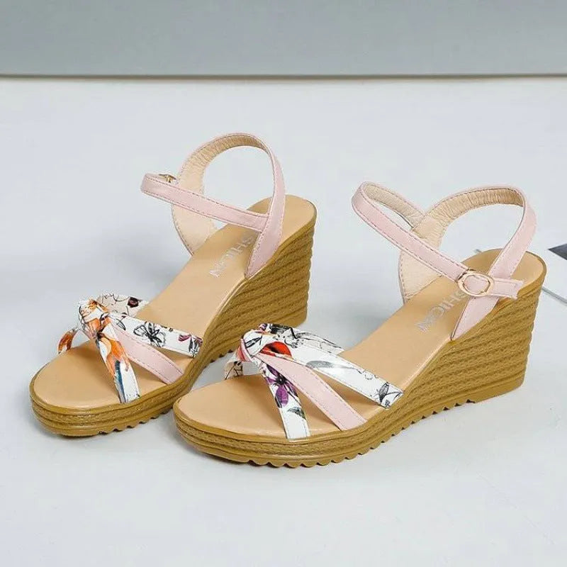 Women's pink wedge sandals with a thick heel, fish mouth design, and a single buckle.