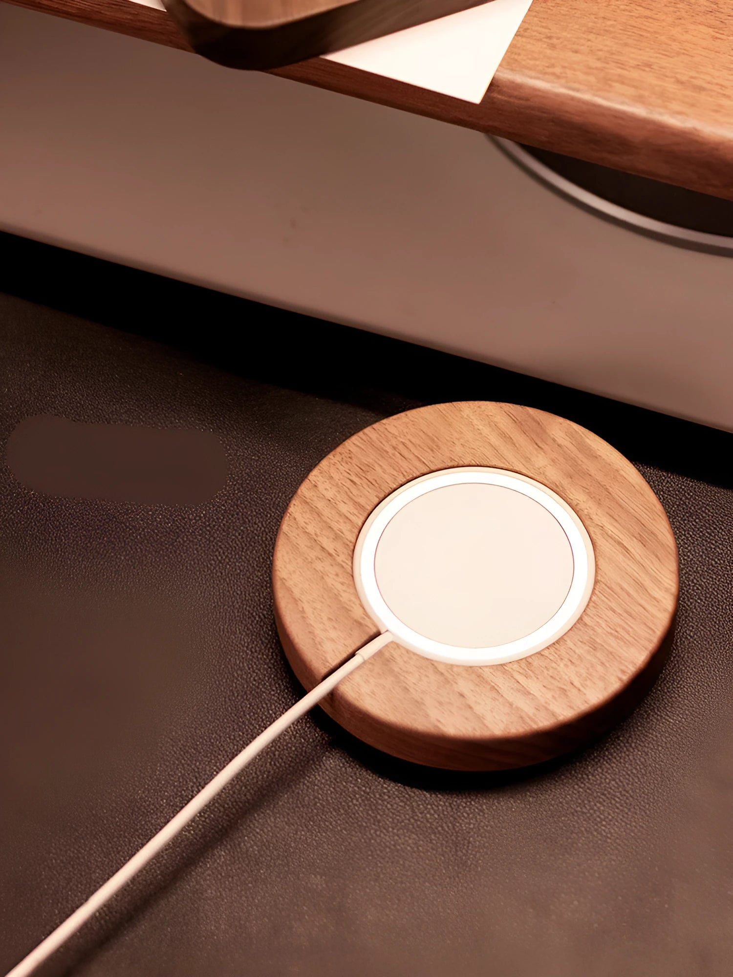 Walnut wood magnetic wireless charging bracket for desktop with phone protective cover.