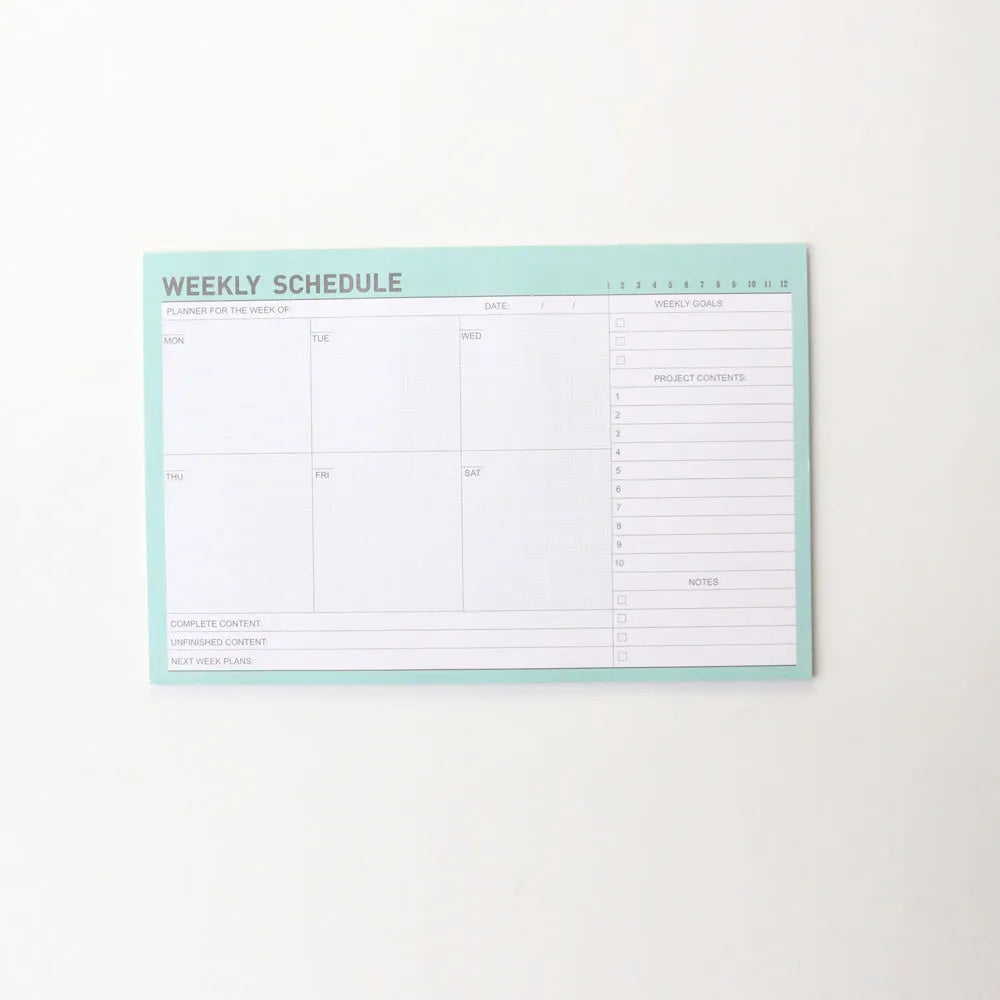 Domikee student desk organiser pad with pink and green planning pages showing weekly and monthly layouts