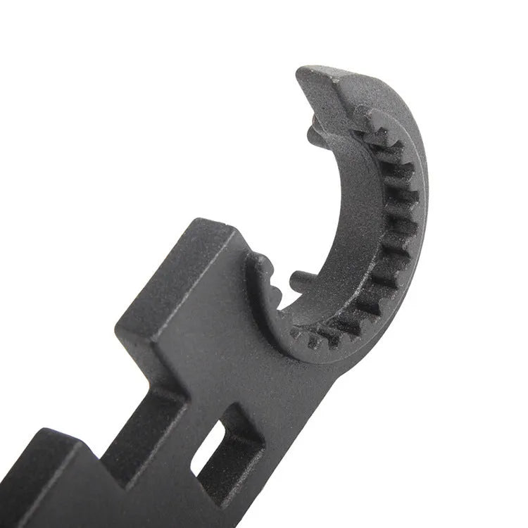 Black steel combination wrench for AR-15 and M4 rifle maintenance on a workshop bench.