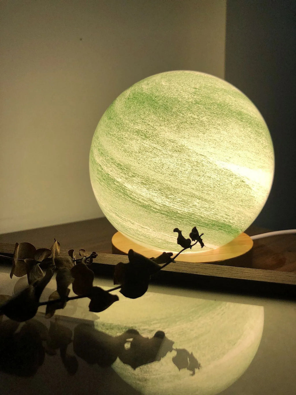 Nordic style Planet Light table lamp with transparent glass shade, shown in emerald green colour.