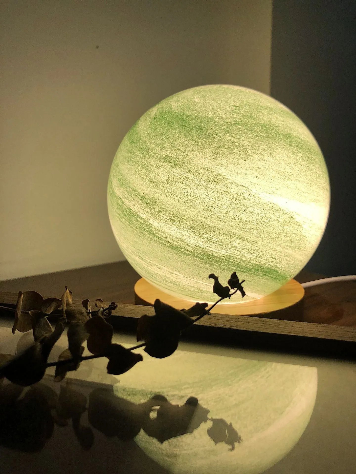 Nordic style Planet Light table lamp with transparent glass shade, shown in emerald green colour.