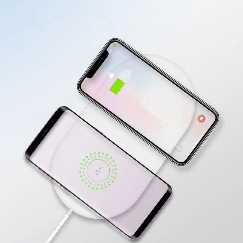 White dual wireless charging pad for two mobile phones on a desk.