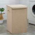 Washable fabric laundry sorting box in beige, shown next to a small pile of towels.