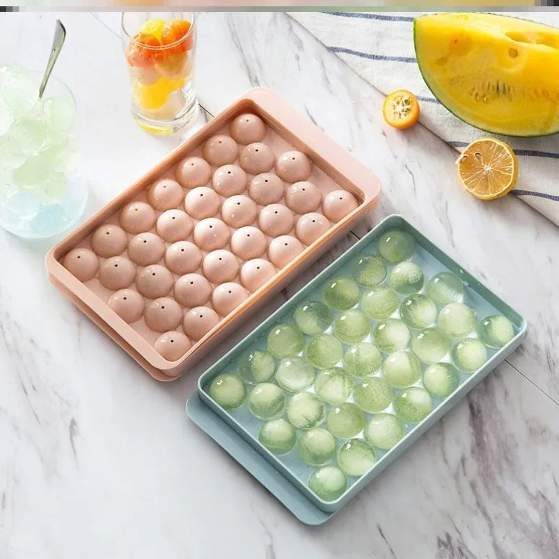 Sky blue 3D round ice ball mould tray with 18 grids next to a pink tray with 33 grids.