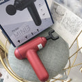 Black, red, and grey fascia gun muscle massager with USB cable