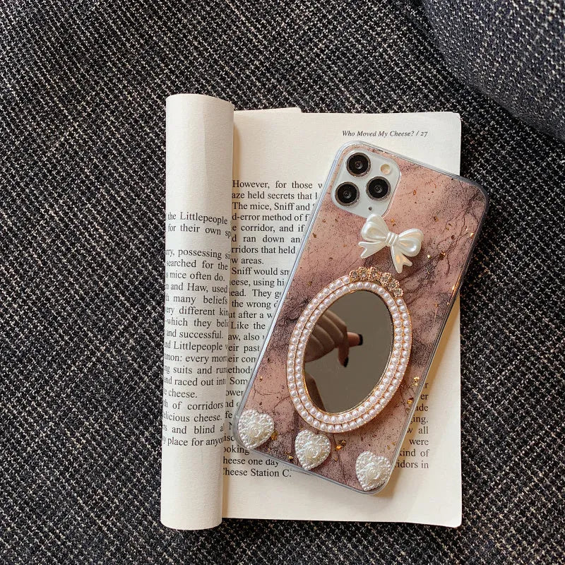 Brown marble pattern silicone iPhone case with rhinestone bowknot and mirror front, shown next to a white colour option.