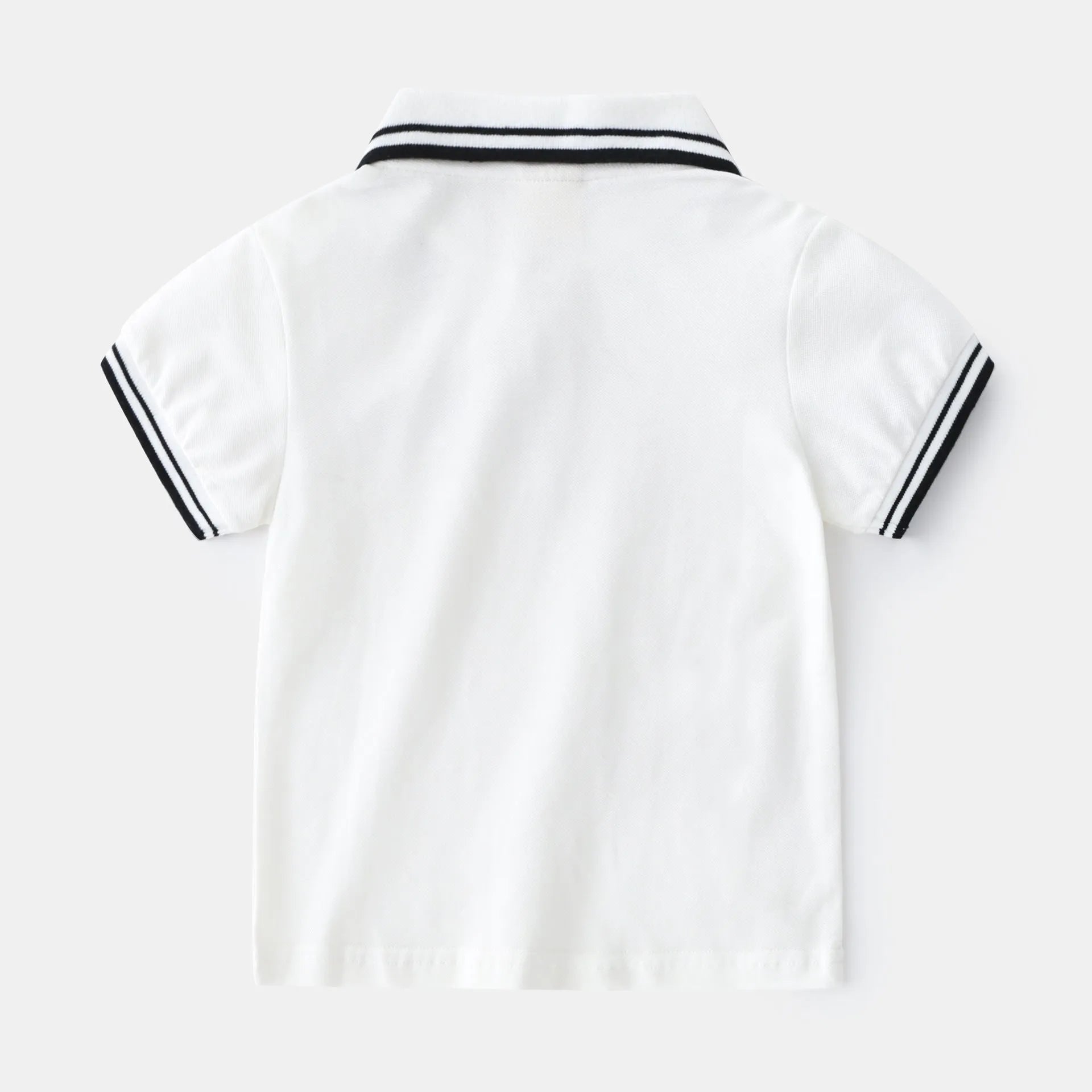 Boys' short sleeve cotton polo t-shirt in white or black, showing round neck and plain front.