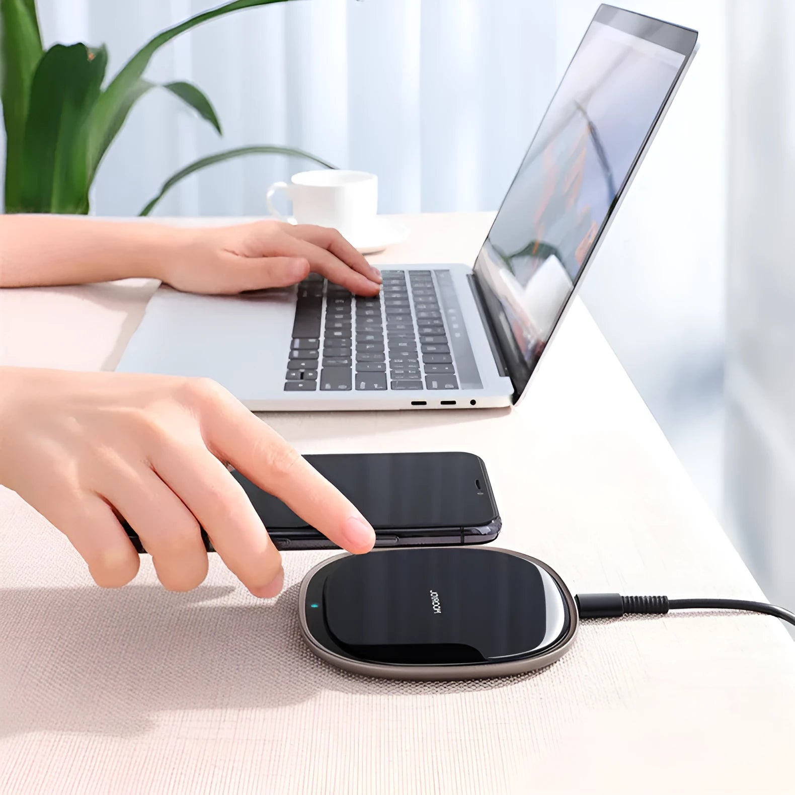 Square black 15W wireless charging pad with glass top and thin zinc alloy frame on a wooden desk
