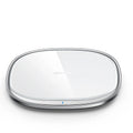 Square black 15W wireless charging pad with glass top and thin zinc alloy frame on a wooden desk