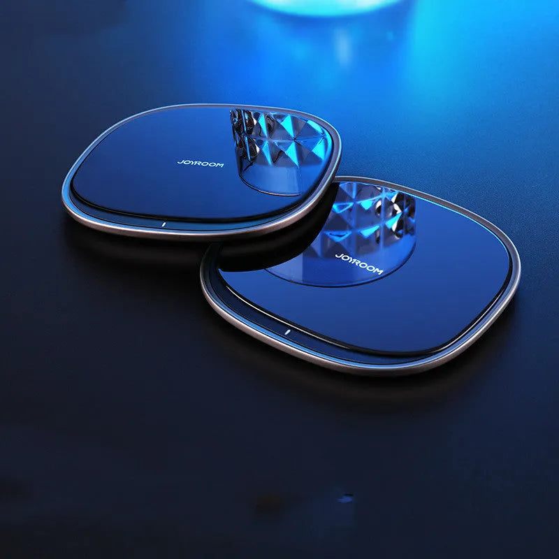 Square black 15W wireless charging pad with glass top and thin zinc alloy frame on a wooden desk
